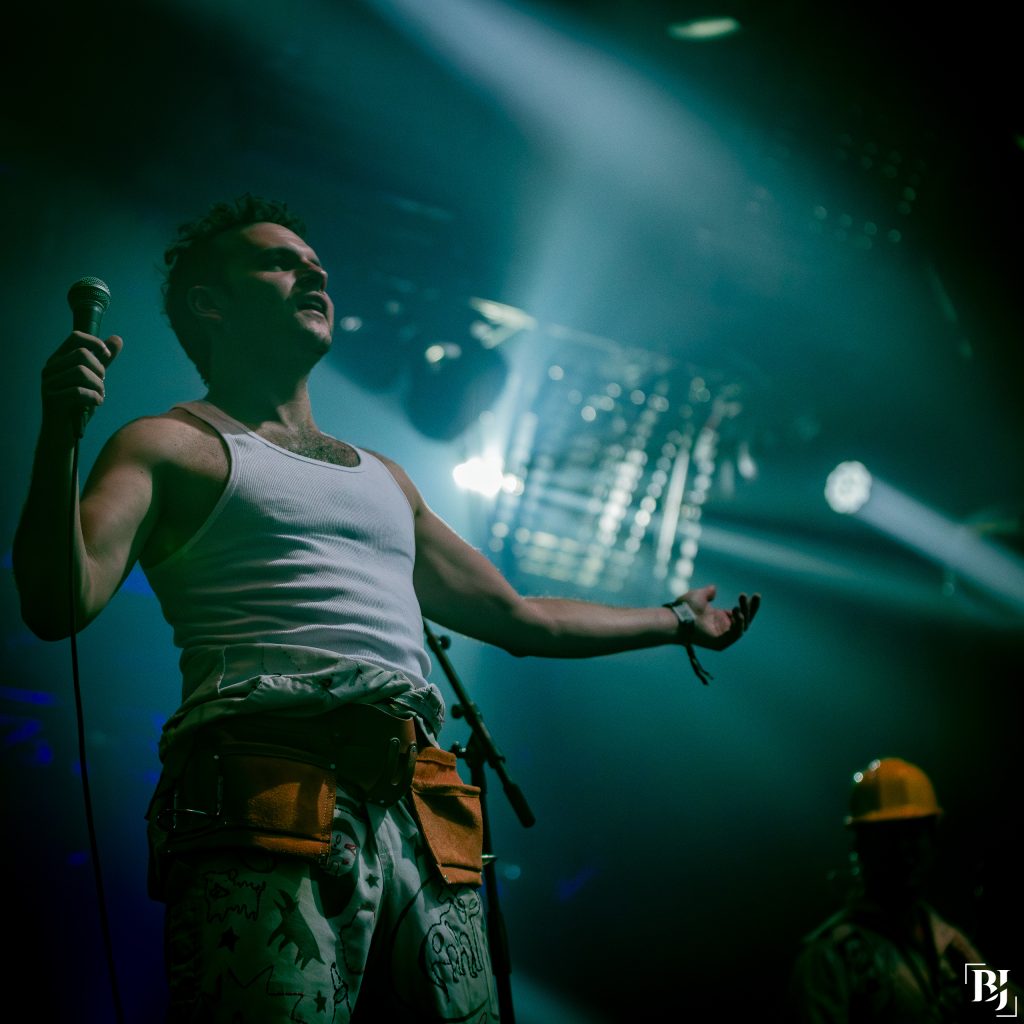 Un homme en débardeur blanc lors d'un concert