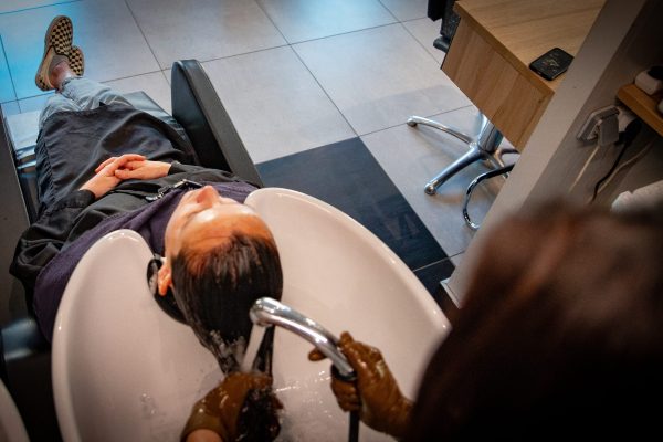une cliente se fait laver les cheveux dans un salon de coiffure